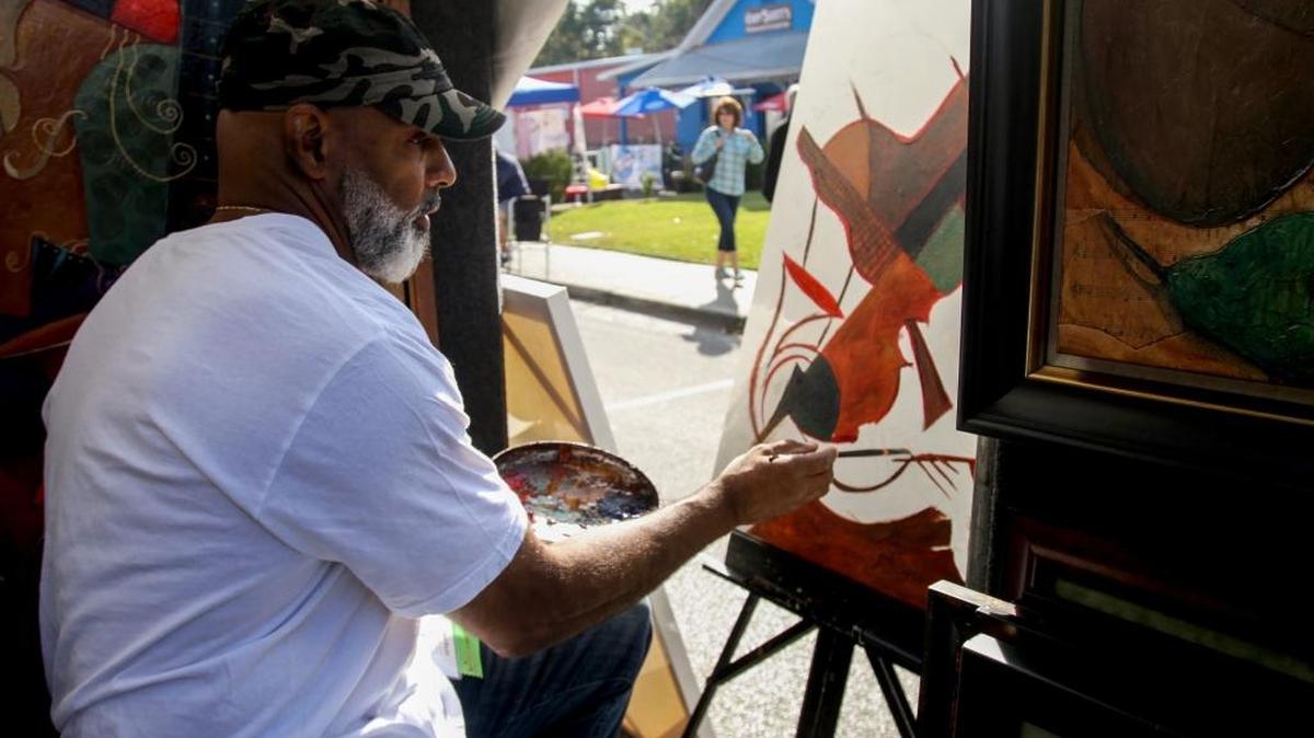 Sidney Carter paints while tending his booth at the 38th annual Peter Anderson Festival on Saturday, November 5, 2016.
