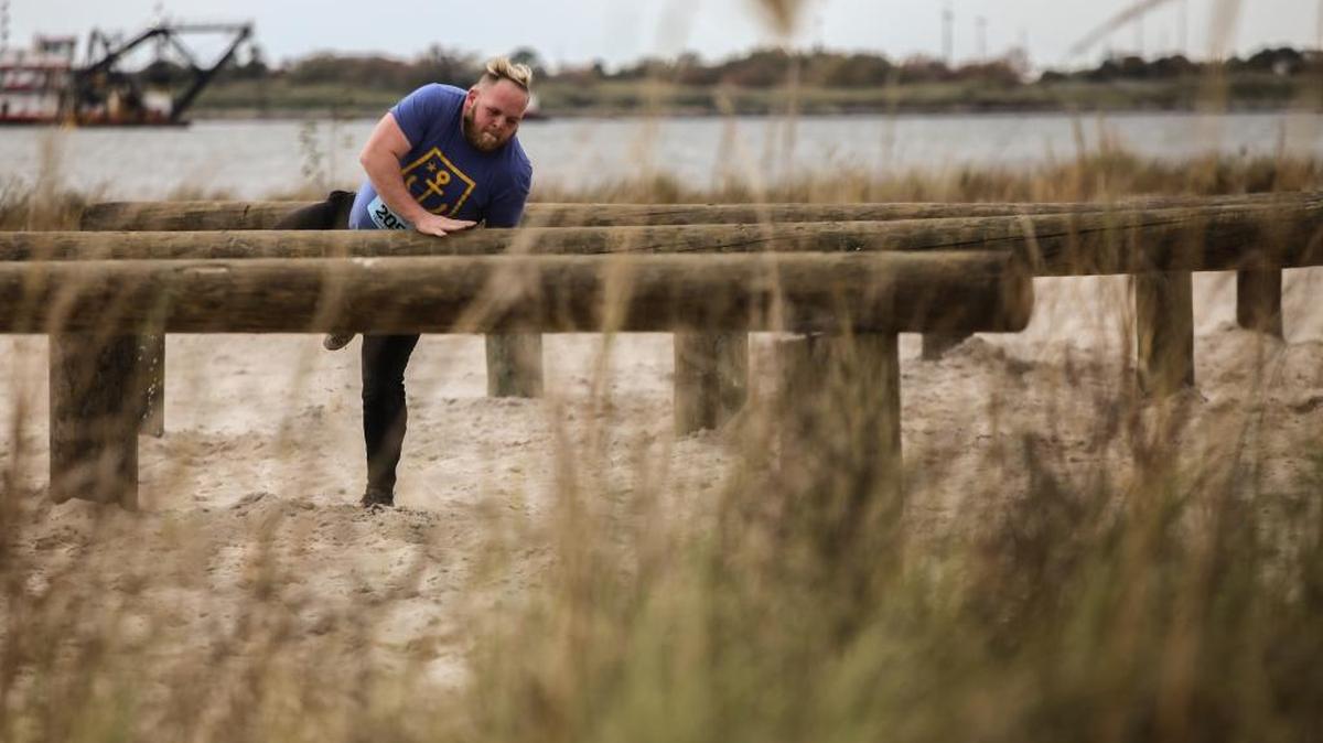 Justin Mitchell climbs over a pole at Battle on Buffett Beach on Dec. 3.