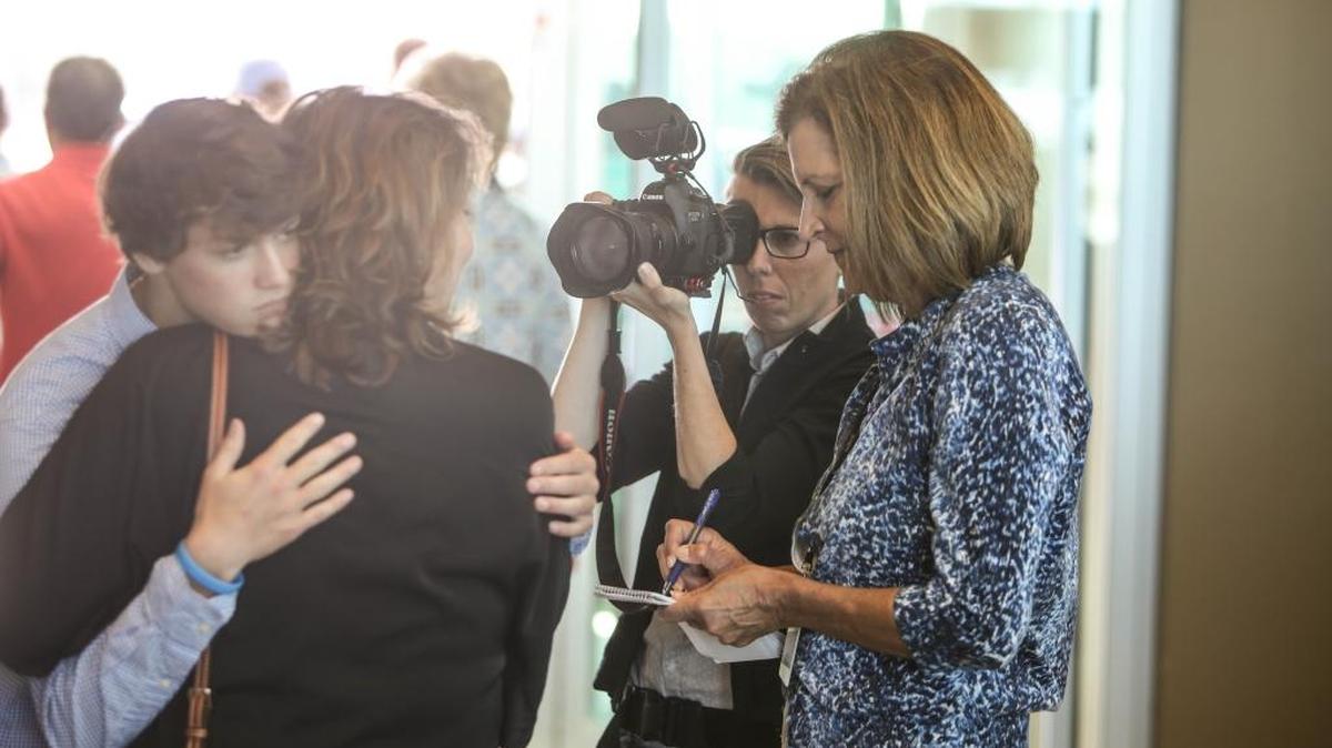 Anita Lee, right, and Amanda McCoy on assignment at John Harrison Doucet’s homecoming at Million Air airport in Gulfport.