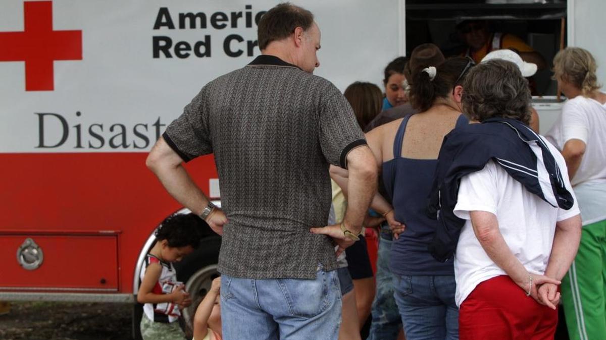 Hurricane Isaac victims stand in line at an American Red Cross mobile feeding truck in September 2012.