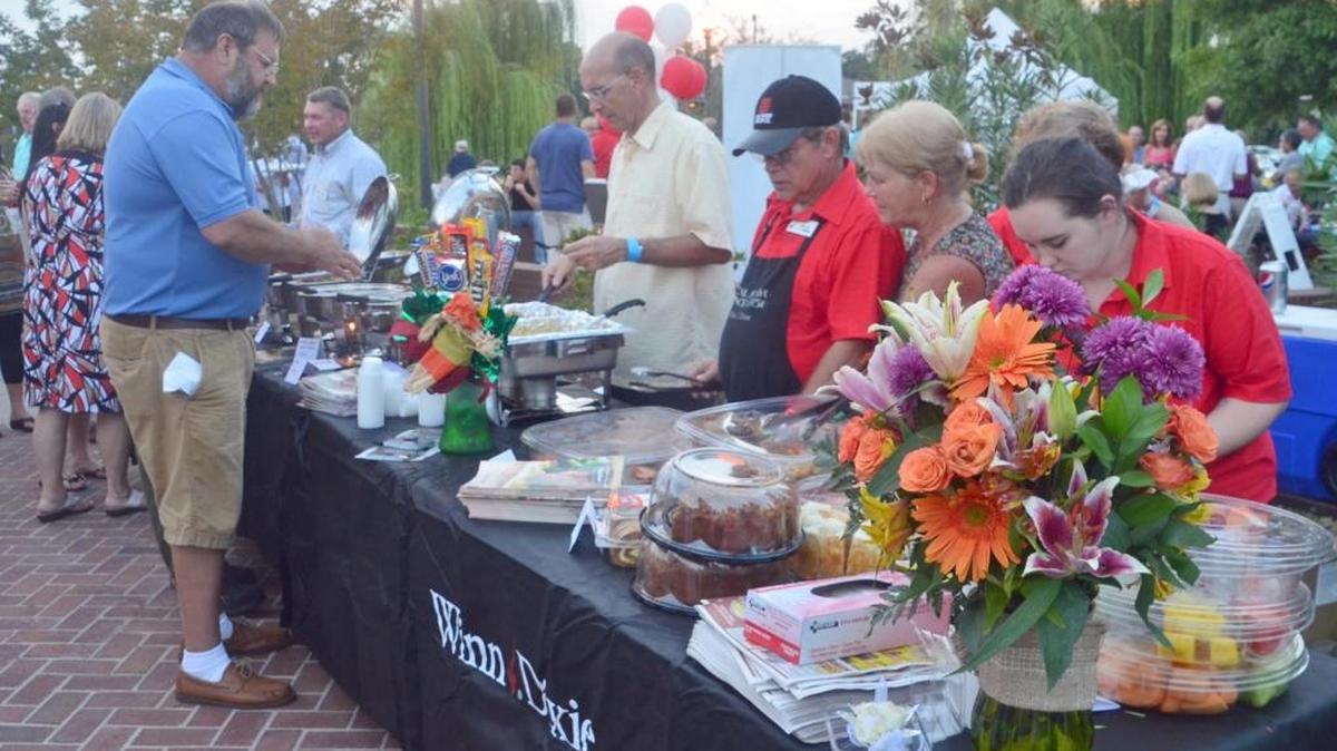 Guests sample food from various stores and restaurants at a past Taste of Long Beach culinary event at the Harper McCaughan Town Green.