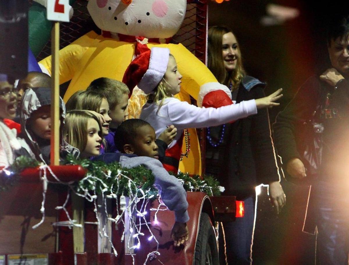 Kids throw candy into the crowd while riding in the Christmas Children’s parade.