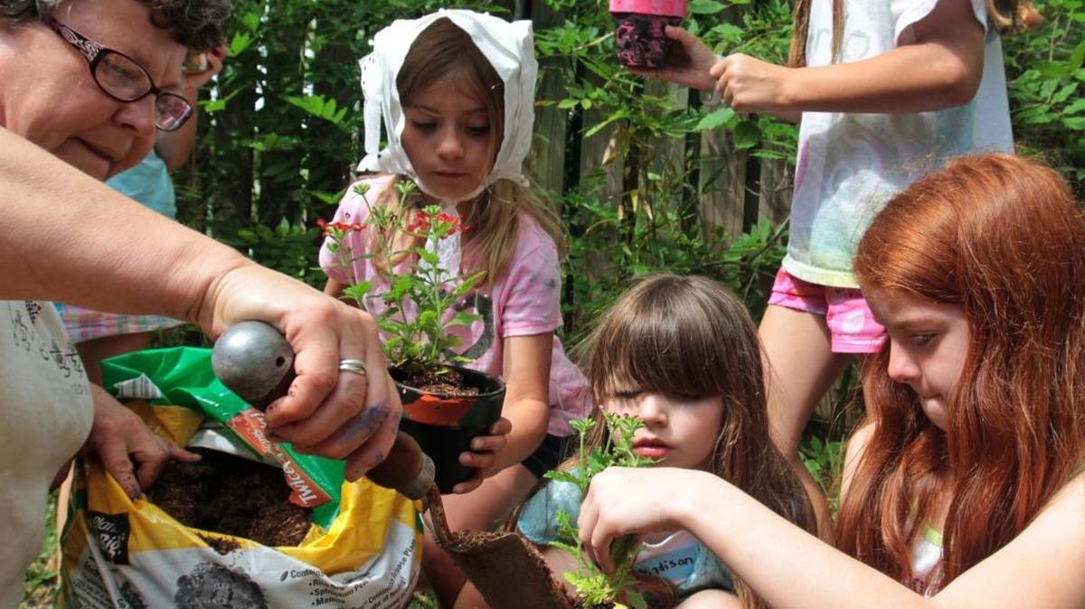 Melissa Johnson, left, helps Jayci Burgess, 6, of Ponchatoula, La., Madison Treace, 7, and Haley Fuelleman, 10, both of Ocean Springs, plant flowers at the Walter Anderson Museum of Art Spring Break Camp at the WAMA Art Cottage in Ocean Springs in 2012. Several camps are available for South Mississippi children.