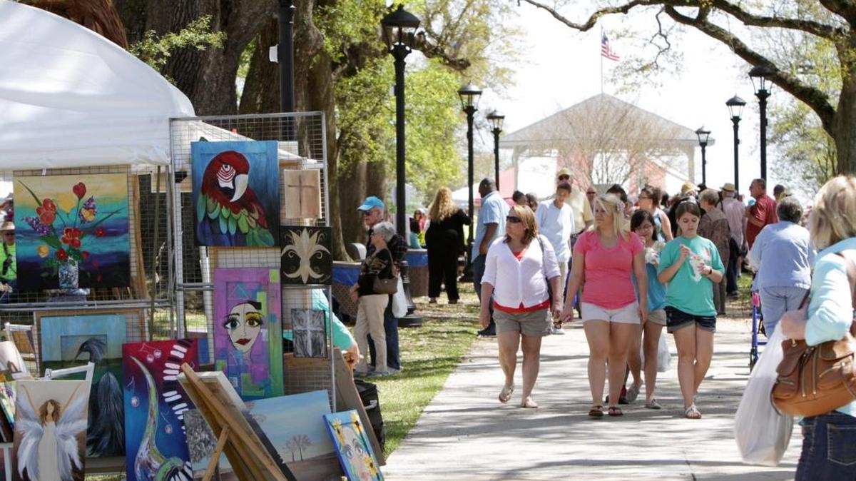 Visitors stroll under the oaks at a past Art in the Pass art festival at War Memorial Park in Pass Christian. The 21st Annual Art in the Pass will be held April 7 and 8 at War Memorial Park.