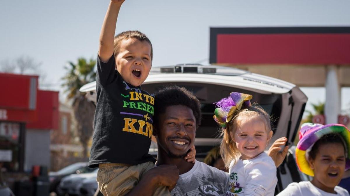 Leroy Johnson Jr. holds up Logan Lee and Belle Hamilton just as the JCCA Parade starts in Pascagoula on Feb. 25, 2017.
