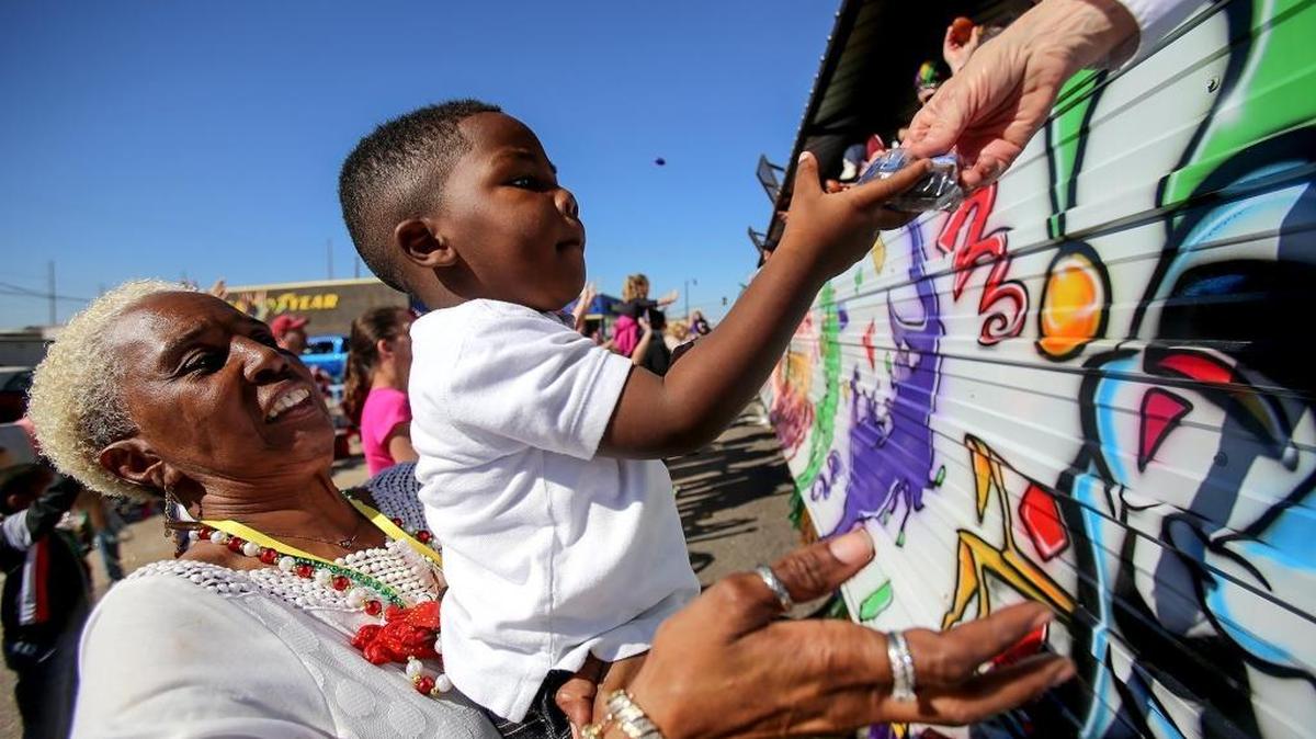 Alice Jonson holds Royal Jefferson, 2, while they gather Mardi Gras swag during the Krewe of Gemini parade on Saturday, February 25, 2017.