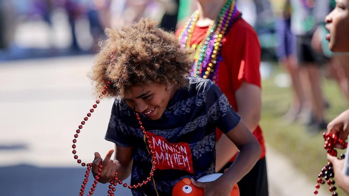 Cejah Tucker, 9, laughs as he untangles himself from a strand of beads while watching the 50th annual Nereids parade roll down U.S. 90 on Sunday, February 19, 2017, in Waveland.