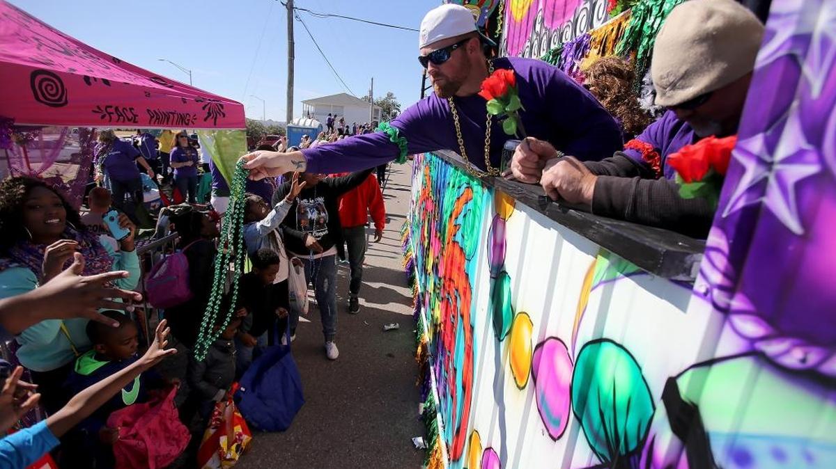 Float riders hand out beads and other throws to the crowd as the St. Paul’s Carnival Association parade rolls through downtown Pass Christian on Sunday, Feb. 7, 2016. The 2017 parade will start at a new time.