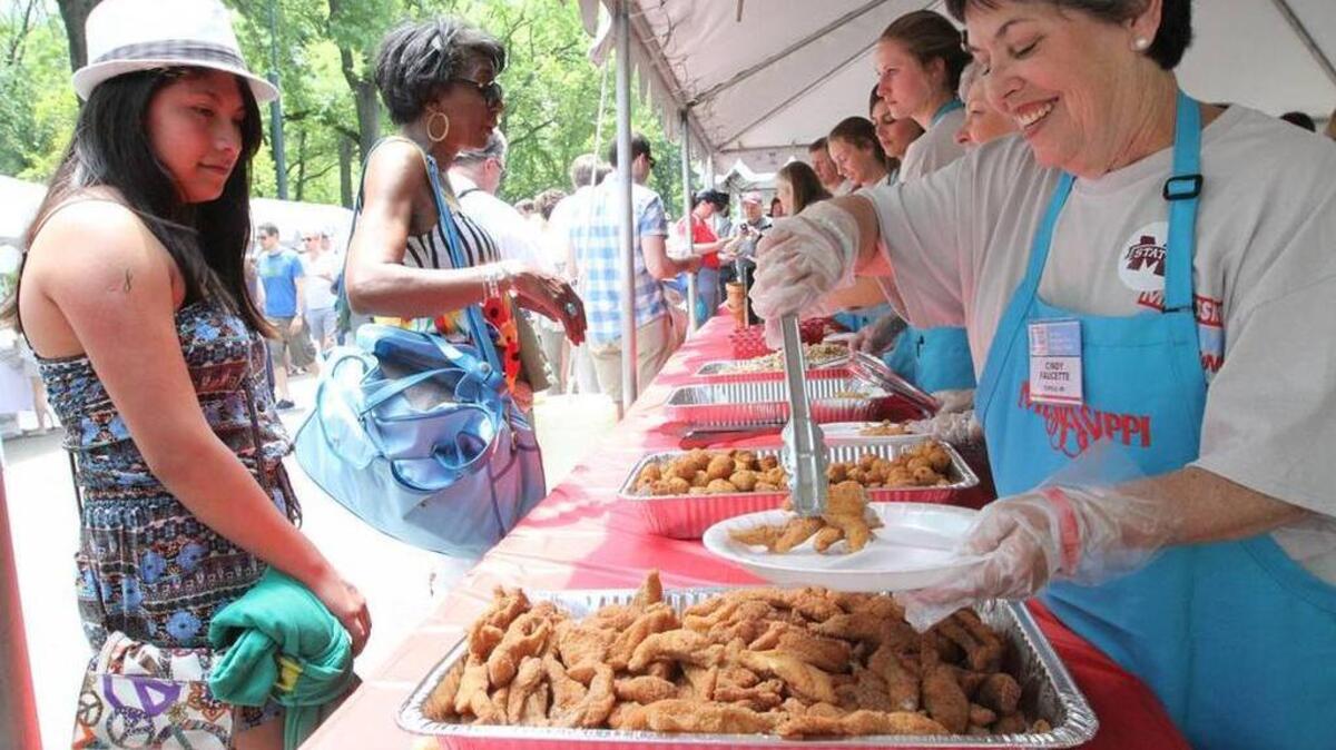 Cindy Faucette of Tupelo, right, plates some fried catfish for those waiting in line at the 35th annual Mississippi Picnic in New York’s Central Park in 2014.