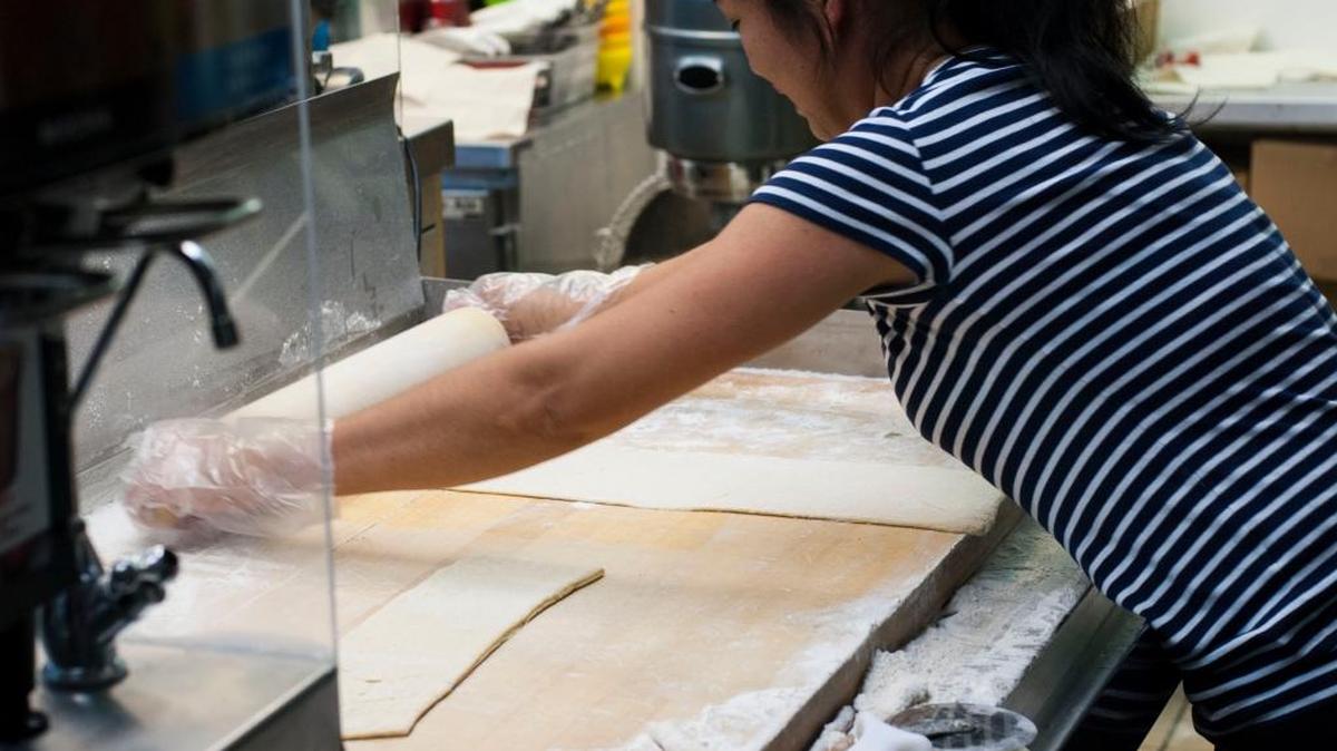 Aivie Mallini rolls beignet dough before cutting it and dropping it into the fryer.