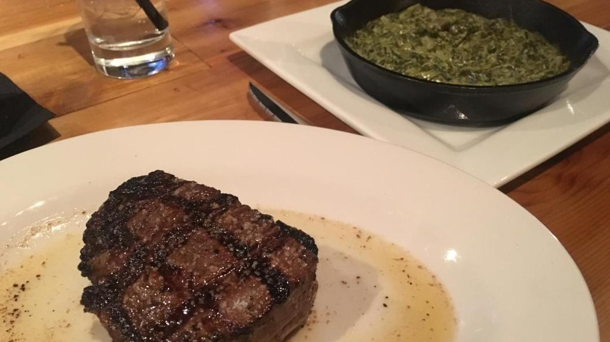 An 8-ounce filet mignon is served with an order of creamed spinach at Whiskey Prime in Pass Christian.