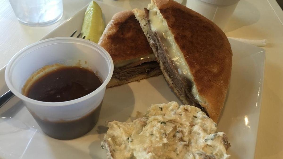 Roast beef on ciabatta is served with gravy and a side of potato salad at Boozer’s Brew & A Cafe Too in Gulfport.