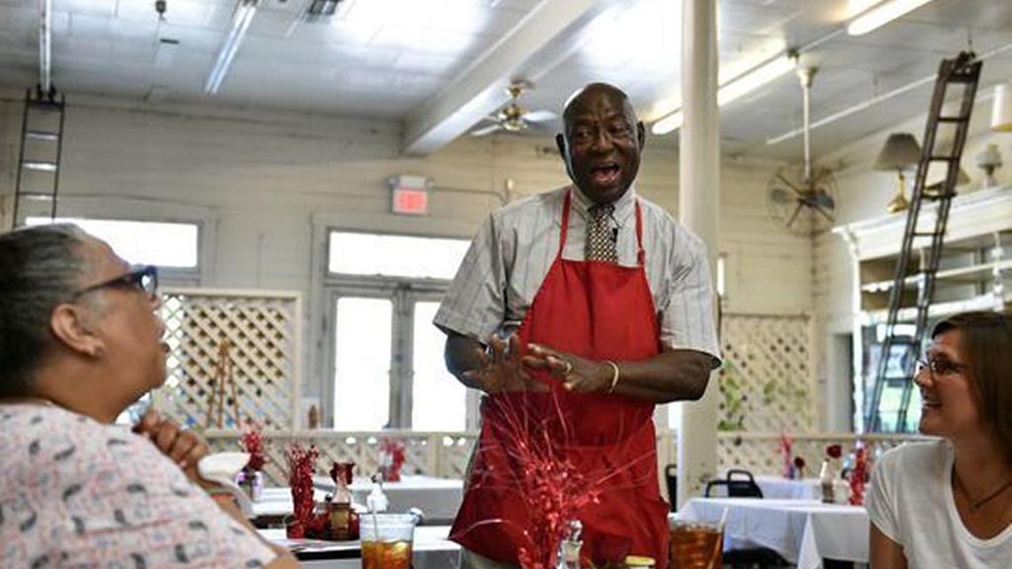 Arthur "Mr. D" Davis sings to Pennsylvania residents Pippa Rex, left, and Kathleen O'Neal on July 19 as they eat at the Old Country Store restaurant in Lorman.