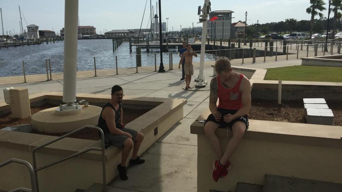 A group of friends sit in the shade and wait for Pokemon to come near enough their phones to be captured at Jones Park in Gulfport, July 9, 2016.