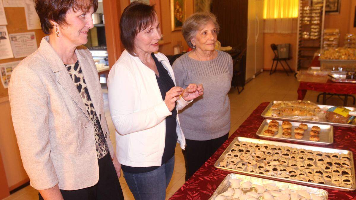 JOHN FITZHUGH/SUN HERALD 
 Mari Ionesco, from left, Natalie Petrovska and Elena Ganges talk about the foods prepared for the Under One Sky ethnic Christmas festival at Holy Trinity Greek Orthodox Church in Biloxi on Tuesday Dec. 8, 2015.