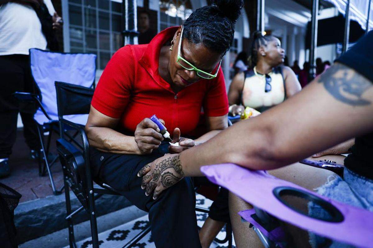 Kim Alexander, who says she has a street performers license, offers Henna on Bourbon street in New Orleans on Sept. 27, 2023.