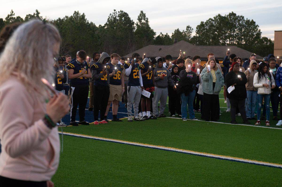 Mourners raise their phone lights during a vigil for Gautier High School student Shermarion Miner at Gautier High School on Thursday, Jan. 16, 2025.