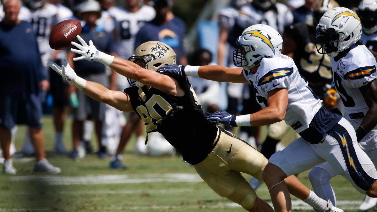 New Orleans Saints wide receiver Austin Carr, left, makes a catch under pressure by Los Angeles Chargers defensive back Micah Hannemann during the teams’ joint NFL football practice, Wednesday, Aug. 22, 2018, in Costa Mesa.