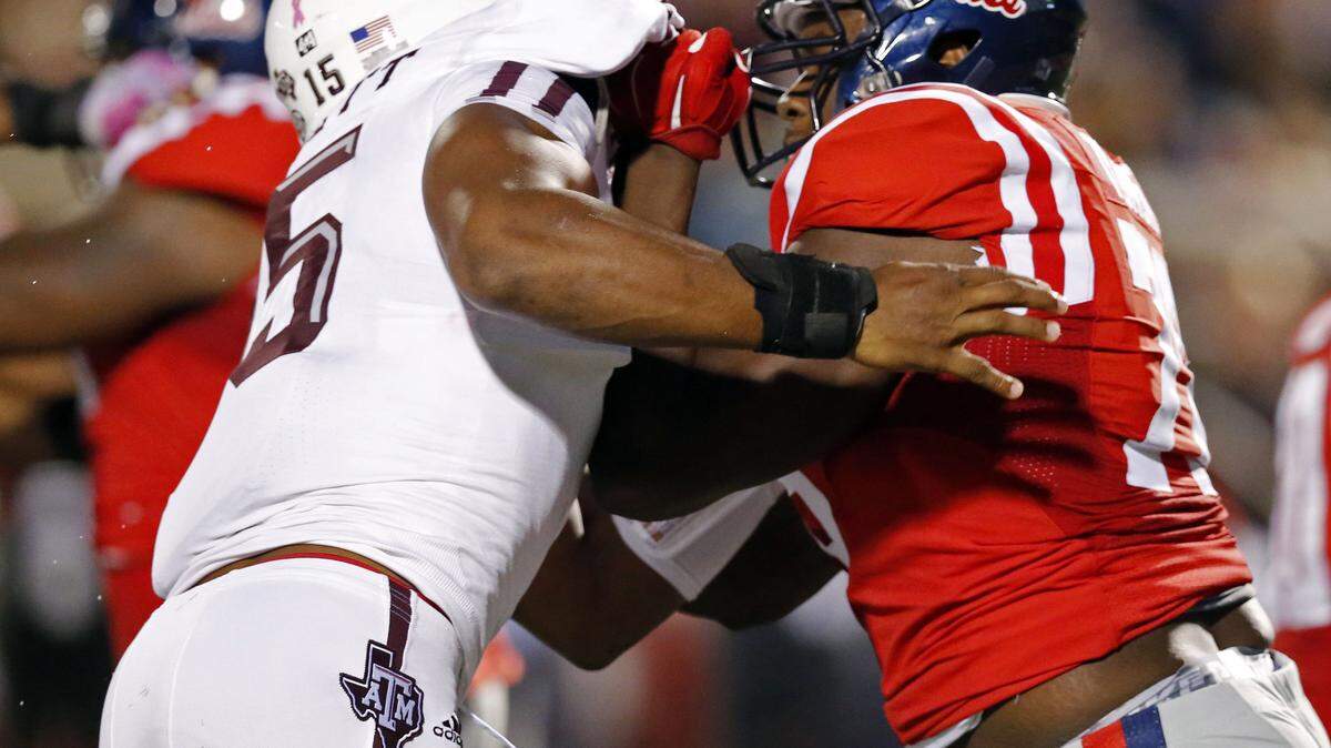 Texas A&M defensive lineman Myles Garrett (15) is locked up by Mississippi offensive lineman Laremy Tunsil (78) during the first half of an NCAA college football game in Oxford, Miss., Saturday, Oct. 24, 2015. (AP Photo/Rogelio V. Solis)