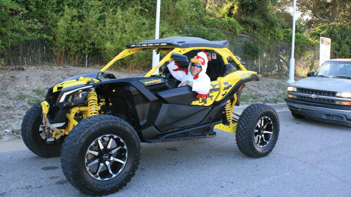 A man, dressed as a chicken, poses in his off road vehicle at the Gulf Coast Coliseum for Scrapin’ the Coast.