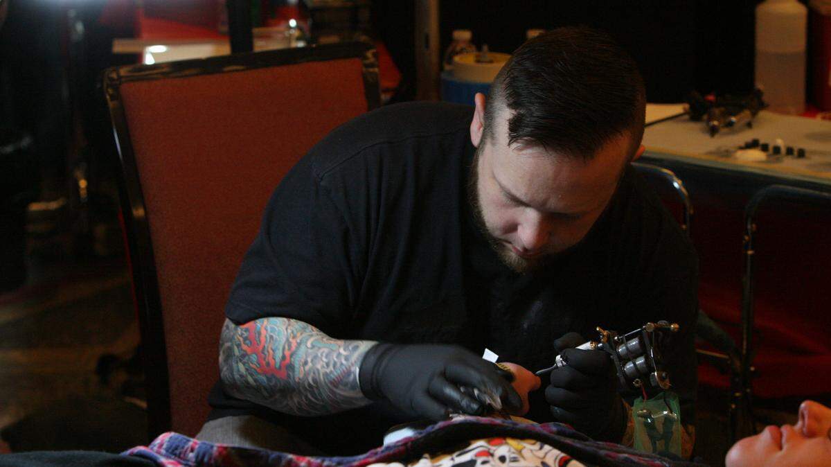 JUSTIN MITCHELL/SUN HERALD 
 Billy Jordan, who works at The Bell Rose in Daphne, Ala., tattoos a client at Due South Tattoo Expo in Biloxi on Sunday, Jan. 31, 2016.