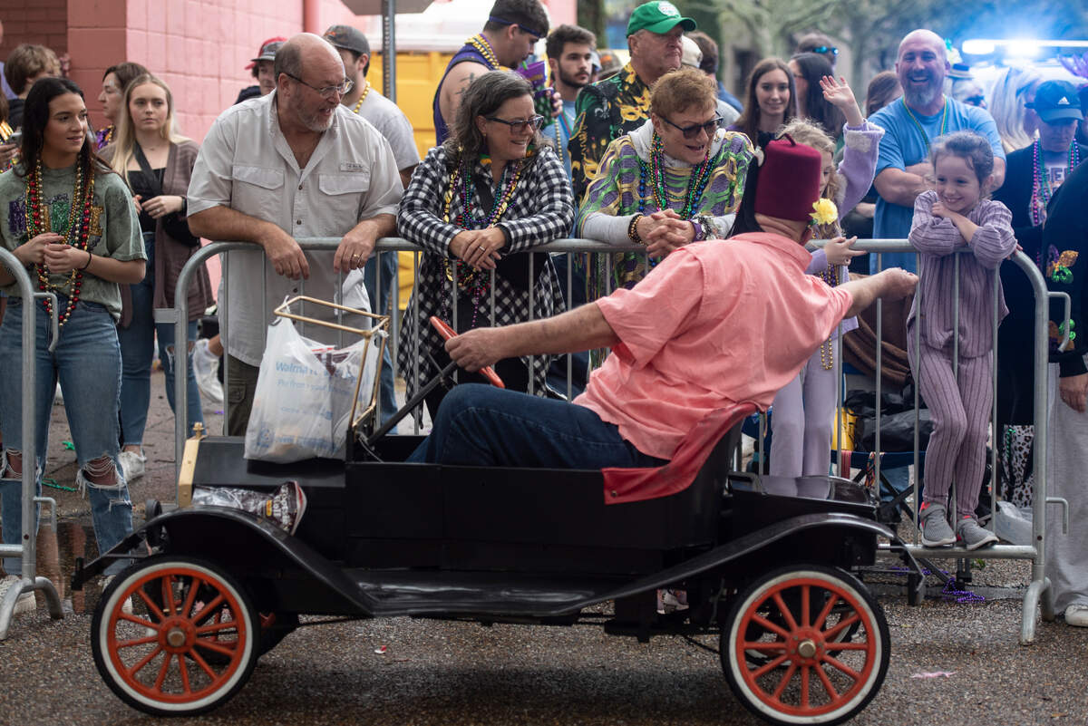 Members of a Shriner’s club pass out throws during the Ocean Springs Elks Carnival Parade in downtown Ocean Springs on Saturday, Jan. 27, 2024.