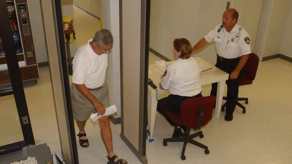 DREW TARTER/SUN HERALD/2005 
 Security officers monitor the metal detector as people step through the device for screening at the Harrison County Courthouse in Biloxi. Metal detectors have been in place in both county courthouses to prevent weapons in the second-floor courtrooms, but now anyone entering a Harrison County Board of Supervisors meeting will be required to pass through a metal detector.