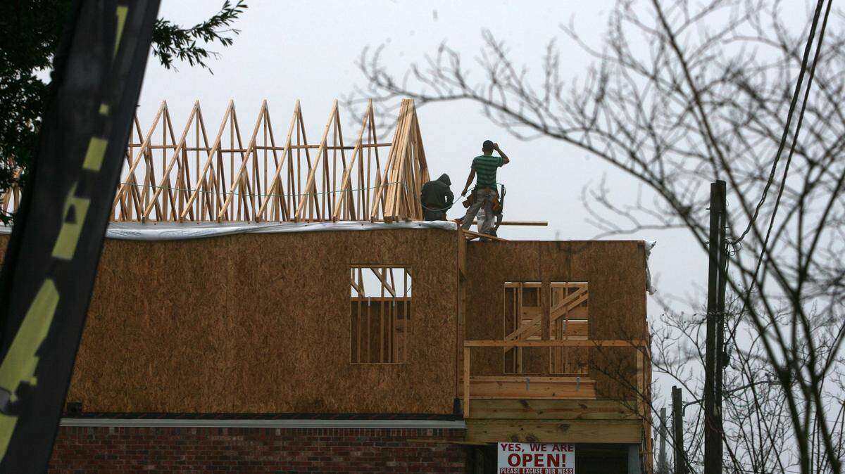 JUSTIN MITCHELL/SUN HERALDConstruction workers work on second-floor apartments on Davis Avenue in Pass Christian despite the rain on Tuesday. Mayor Chipper McDermott said they city has its eyes on mixed-use space construction to appeal to tourists looking to rent a place in South Mississippi.