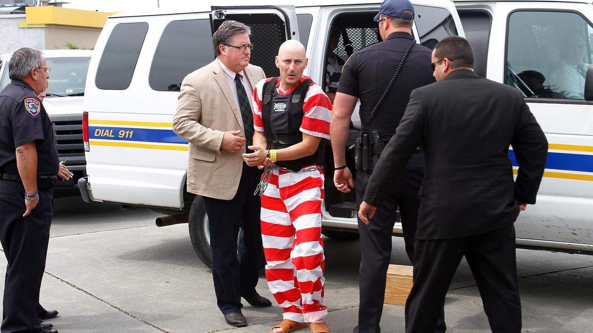 AMANDA McCOY/SUN HERALD 
 Glen Joseph Davis is escorted into the Bay St. Louis Municipal Court in 2012 for a preliminary hearing in the capital murder of retired businessman Maurice Colly, 83. Joseph Kepfer III, who had been lead detective on the case, was fired for falsely implicating another man as a person of interest, among other reasons. Kepfer had sued the city but a judge upheld his firing Monday.