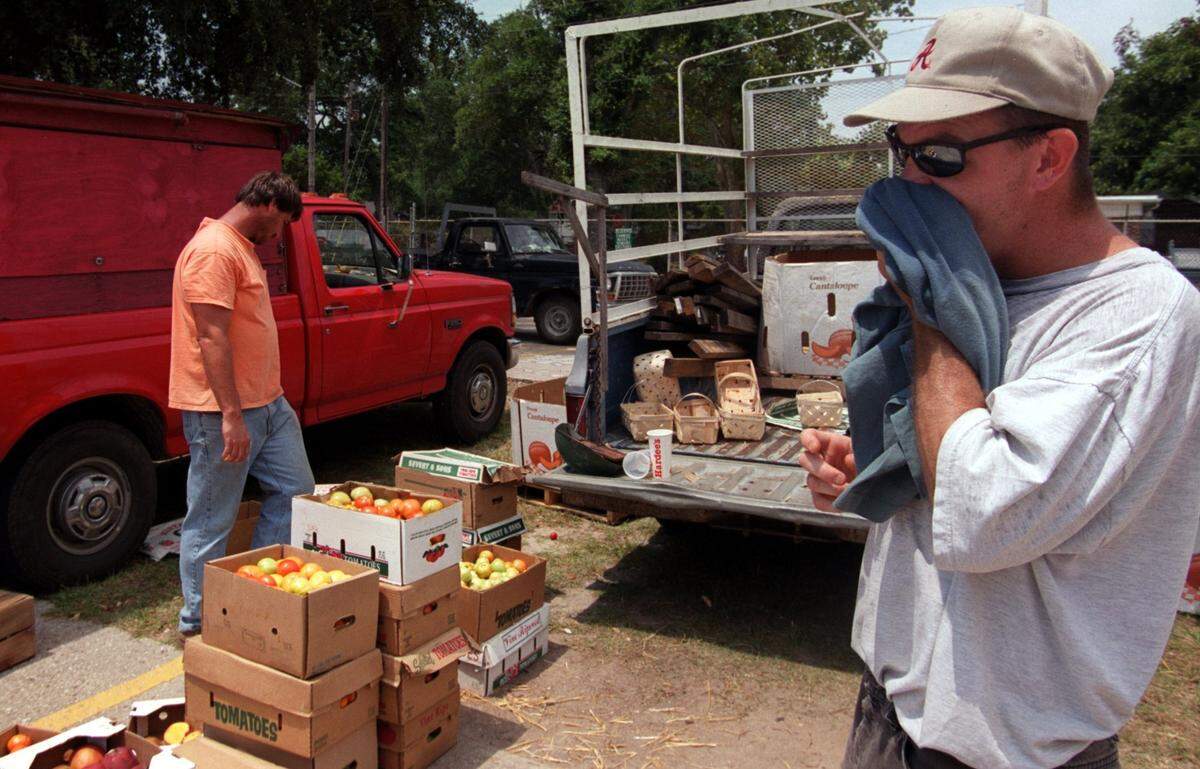 Charles Jones of Mobile uses a t-shirt to wipe the sweat from his face on July 19, 2000 while selling vegetables and fruit at the Farmers Market at Point Cadet in Biloxi. “I’m pretty much use to it (the heat) being from the south. I guess it effects us all”, Jones said.