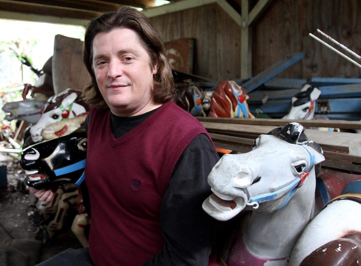 Rafe O’Neal poses with some of the 36 FunTime merry-go-round horses in storage, Tuesday, Jan. 26, 2016.