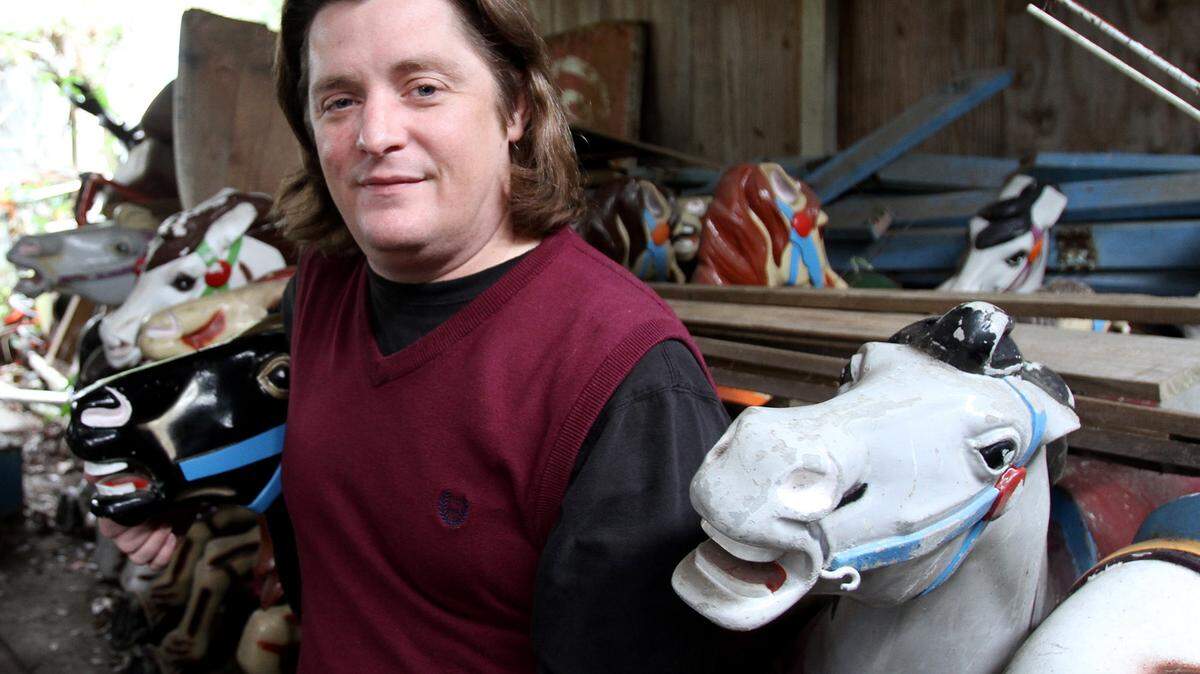 Rafe O’Neal poses with some of the 36 FunTime merry-go-round horses in storage, Tuesday, Jan. 26, 2016.