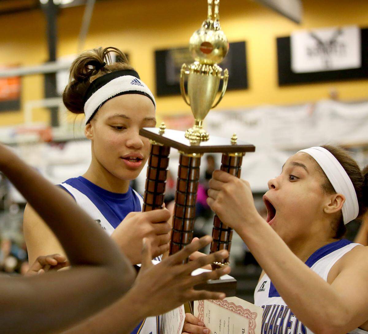 AMANDA McCOY/SUN HERALD  St. Martin's Daphne White, left, and Deona Morgan react after receiving the Region 7-6A title trophy on Friday, Feb. 19, 2016.