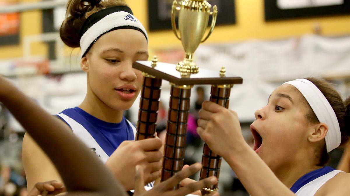 AMANDA McCOY/SUN HERALD 
 St. Martin's Daphne White, left, and Deona Morgan react after receiving the Region 7-6A title trophy on Friday, Feb. 19, 2016.
