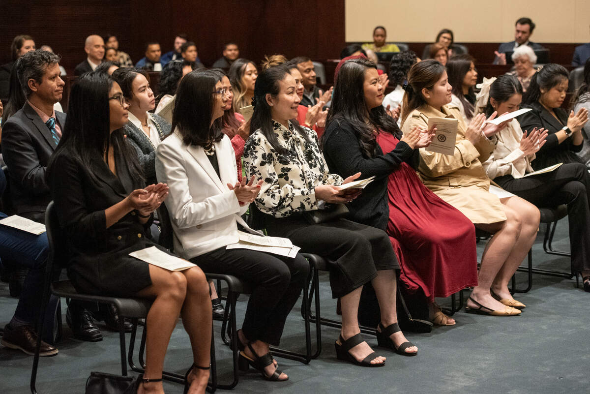 Newly naturalized American citizens clap during a naturalization ceremony at Dan M. Russell Courthouse in Gulfport on Thursday, Oct. 19, 2023.