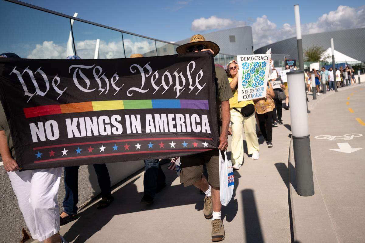 Protesters carry banners and signs Saturday.