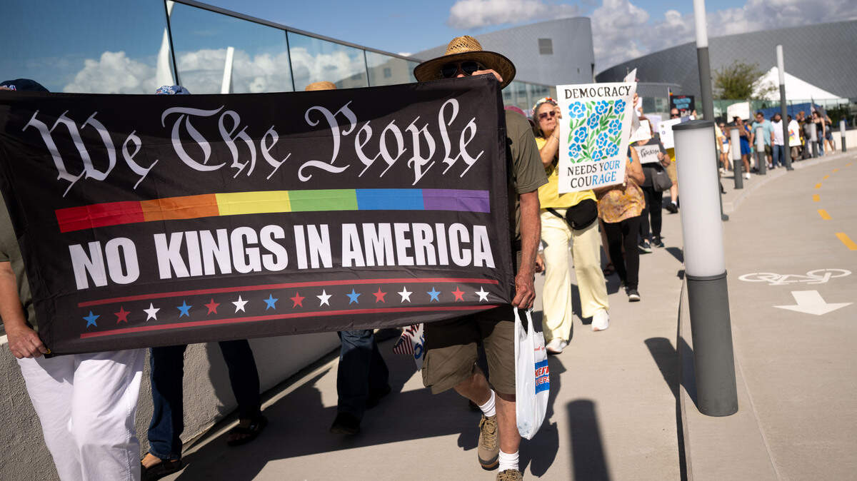 Protesters carry banners and signs across a bridge to Jones Park during a No Kings protest in Gulfport on Saturday, October. 18, 2025.