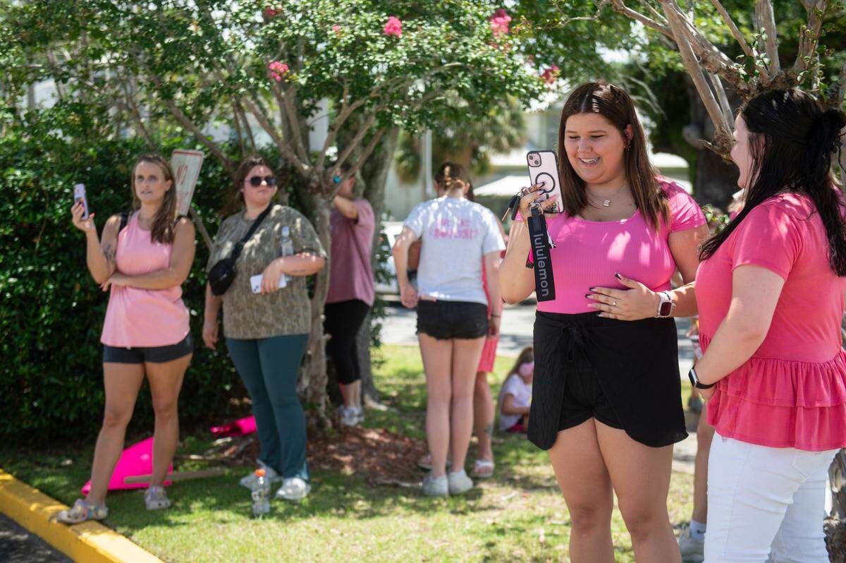 Protestors in support of Heather Wyatt and Aubreigh Wyatt hold signs, take photos and livestream on various social media platforms outside the Jackson County Courts building on Thursday, July 18, 2024, as Heather Wyatt participates in a chancery court hearing inside the courthouse.