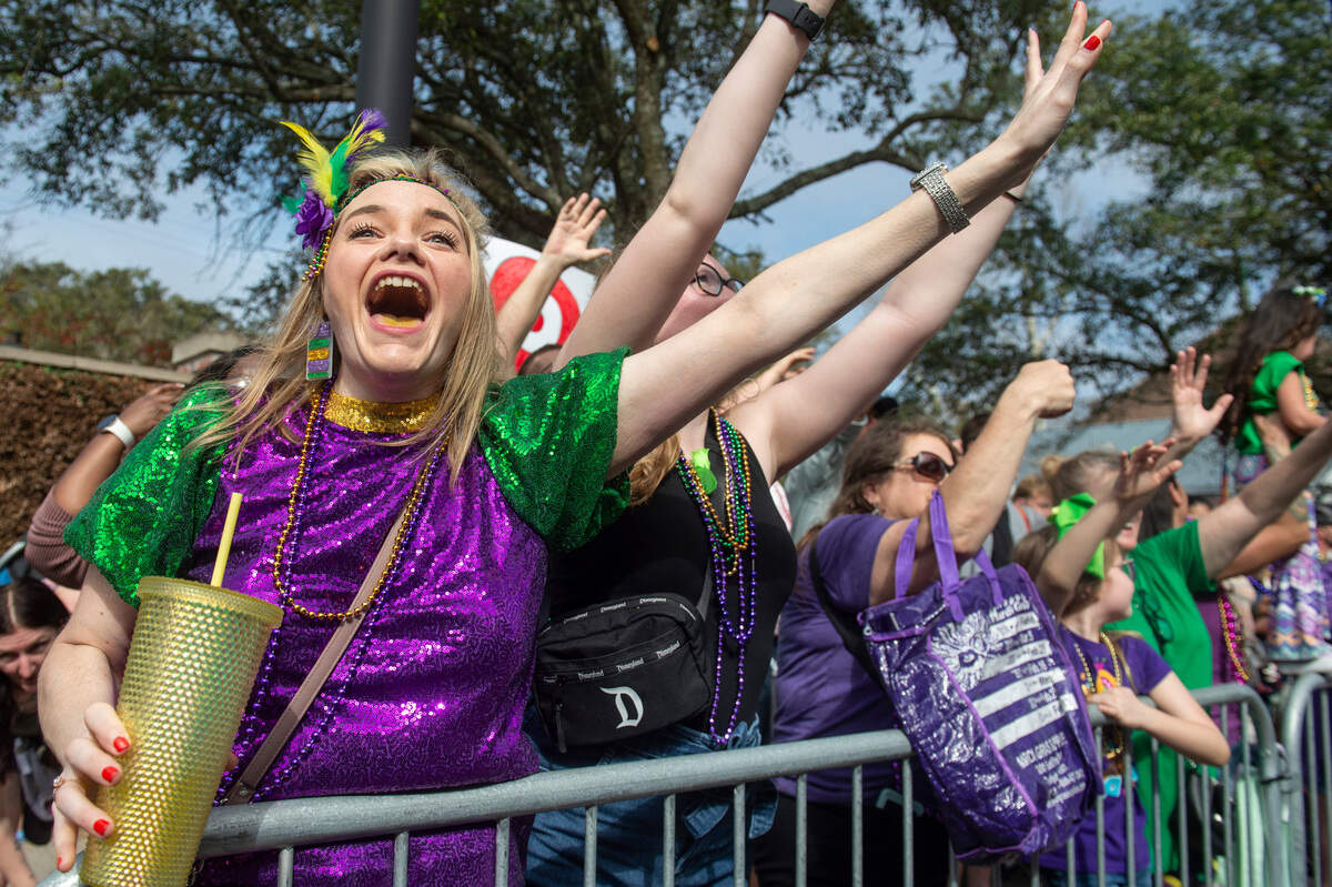 Parade watchers cheer for throws during the Ocean Springs Elks Club Mardi Gras Parade in Ocean Springs on Saturday, Feb. 15, 2025.
