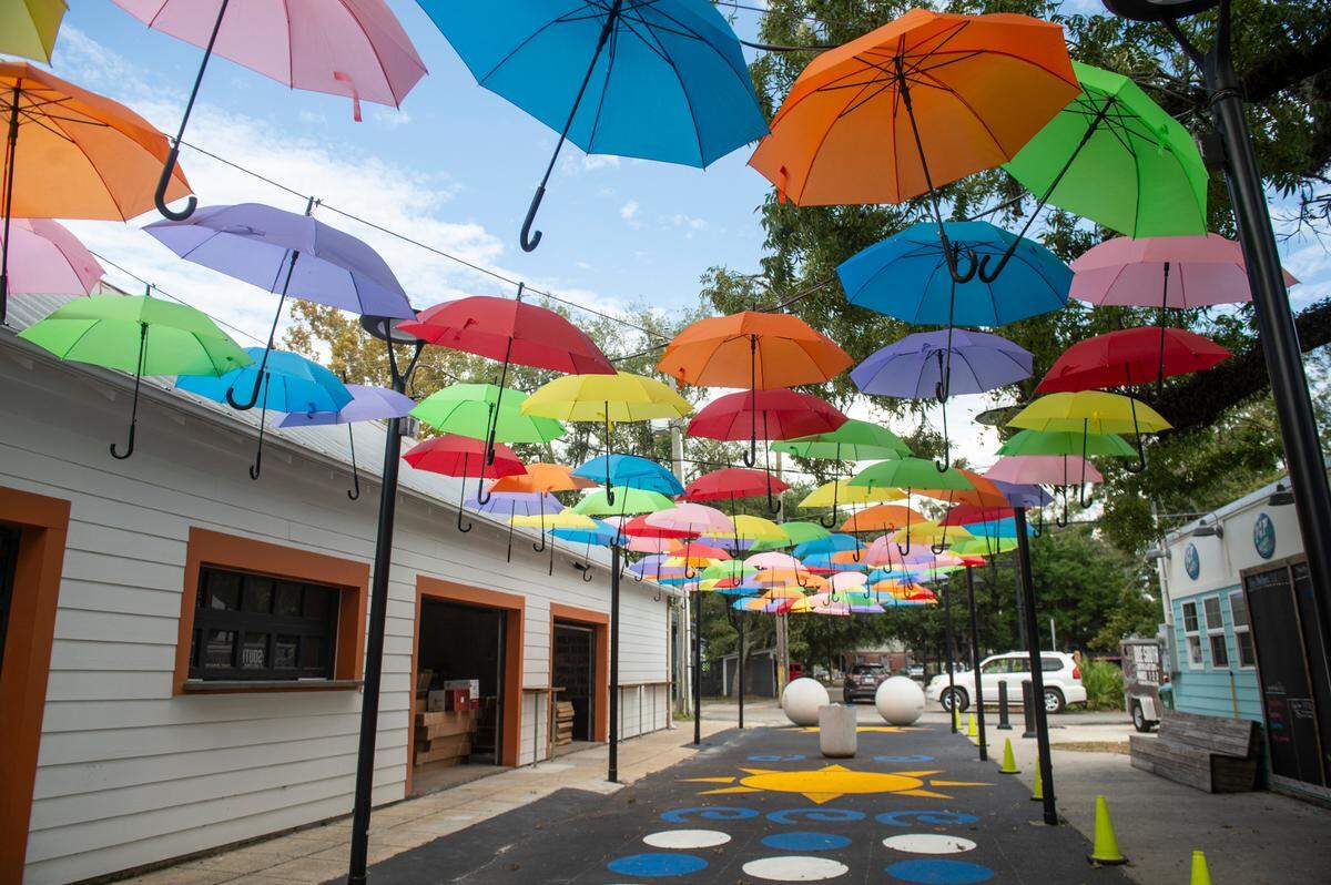 A colorful umbrella sky and a mural pathway decorate Cash Alley in downtown Ocean Springs, where several new businesses are opening this fall and into early 2025.