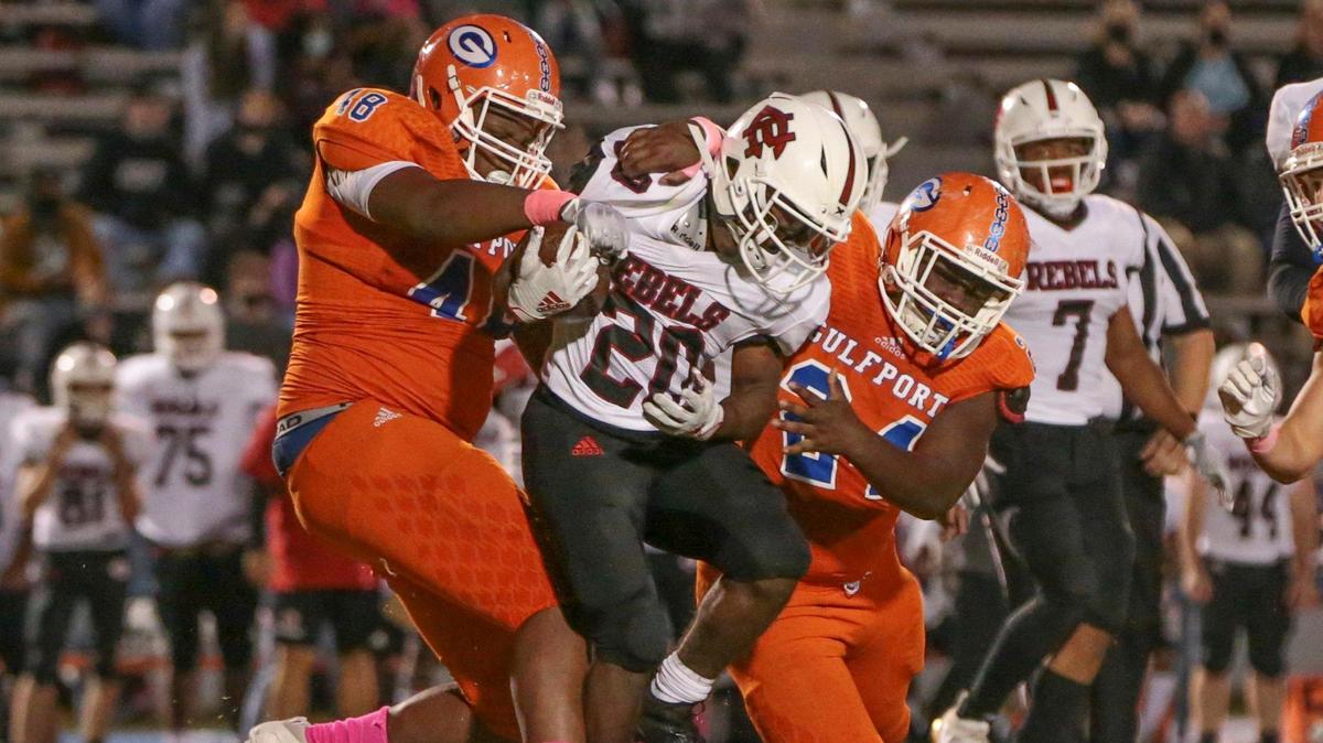 Harrison Central running back Atavian Ray (20) is tackled by Gulfport defensive lineman Tyreese Williams (24) and defensive lineman David Lewis (48) during the game between Harrison Central and Gulfport, Friday, October 16, 2020.