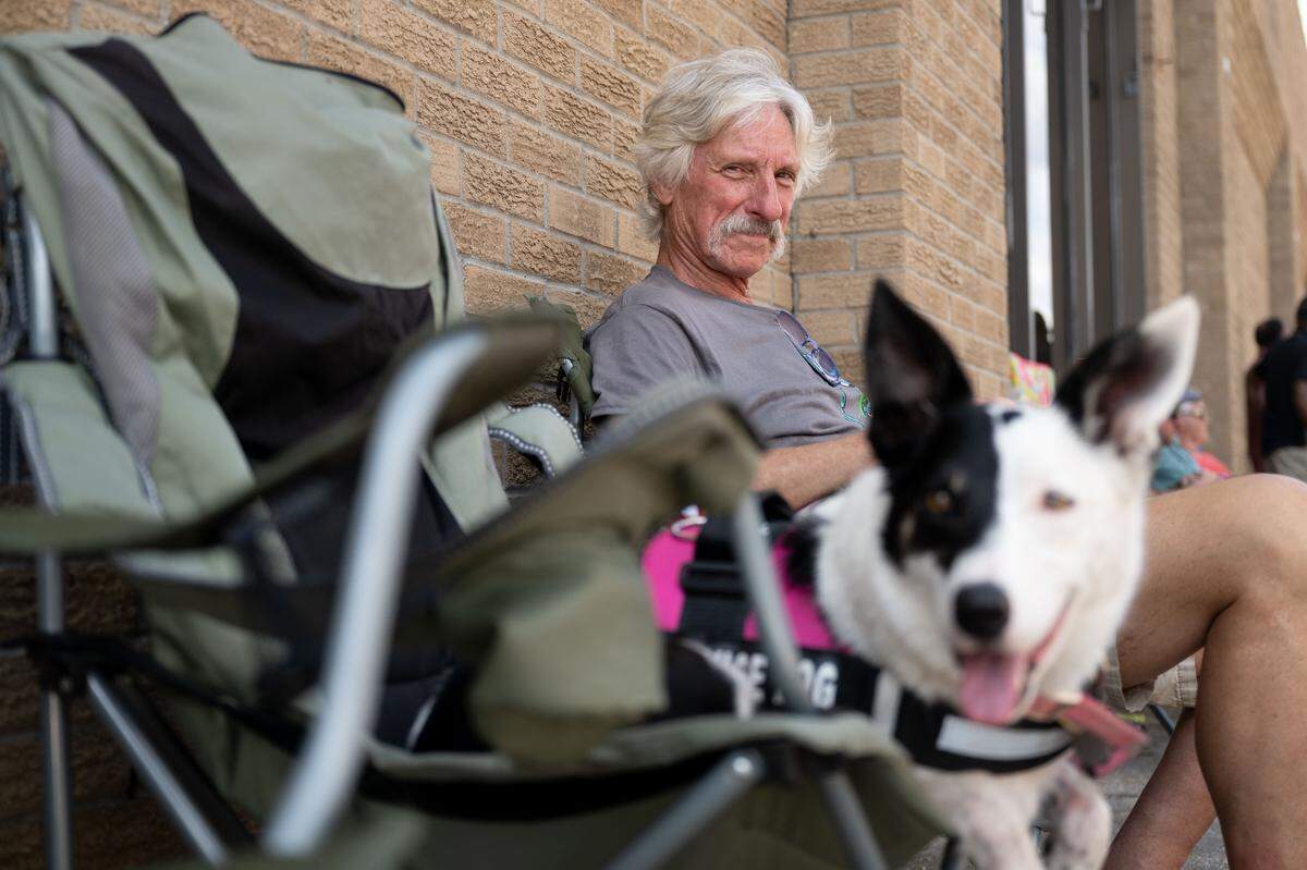 Matt Pace sits with Fridge, his service dog, during the Biloxi Block Party.