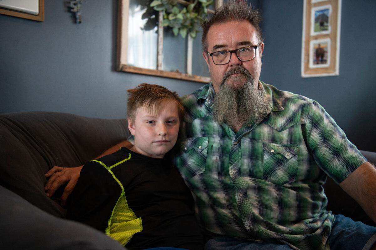 Bill McLarty, right, and his son Chris, 12, at their Jackson County home on Wednesday, June 7, 2023. Bill McLarty wants tougher laws for vicious dogs because Chris has been attacked twice by a neighbor’s pit bull, suffering a severe leg injury the second time. The pit bull still lives a few houses down.