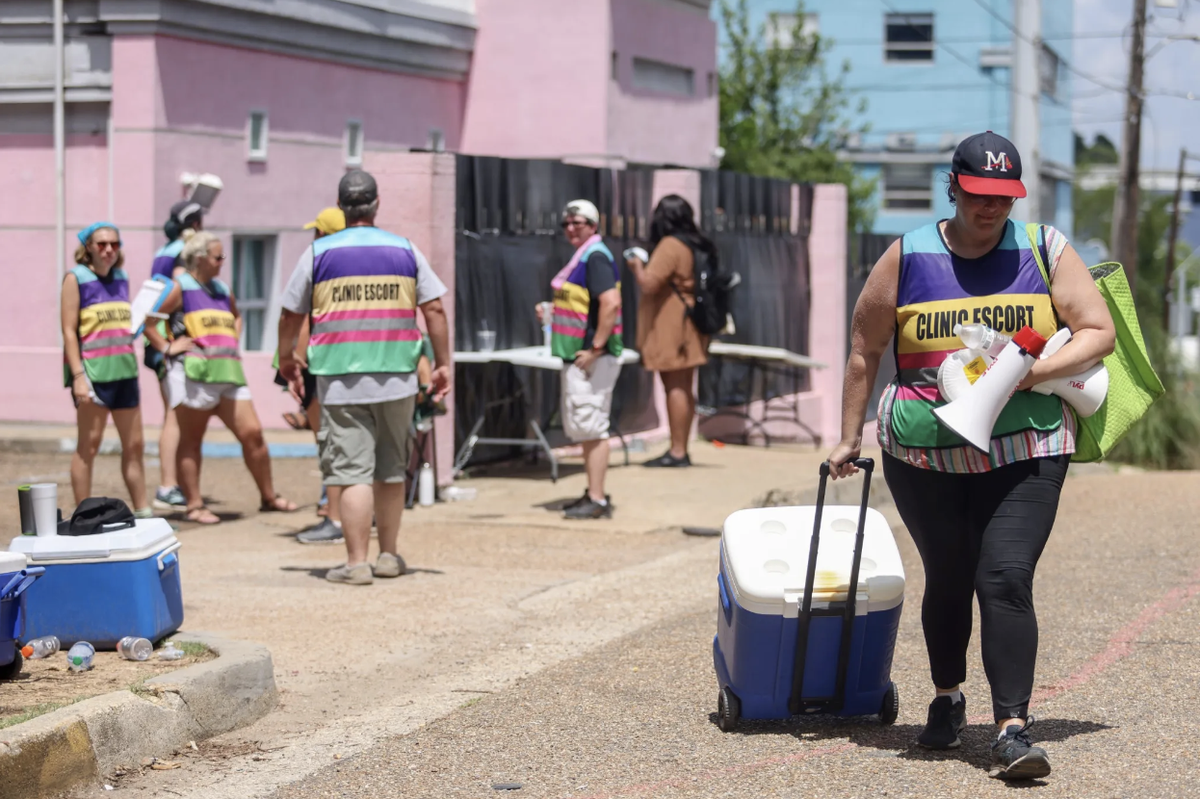 Clinic escort Rose Kasrai leaves the Jackson Women’s Health Organization in Jackson, Miss., Wednesday, July 6, 2022. The clinic must stop providing abortions after a judge refused to block the state’s trigger law from taking effect.