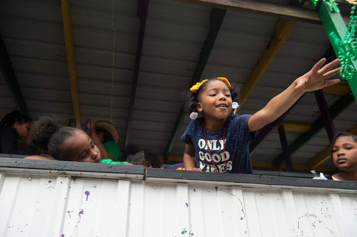 Children throw beads from a float during the Krewe of Gemini parade in downtown Gulfport on Saturday, Feb. 10, 2024.