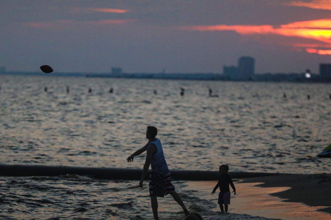 A family throws a football at sunset on the beach in Gulfport amid the coronavirus pandemic on Monday, March 16, 2020. Five years later, remote workers have emerged as one sign of the pandemic’s enduring legacy.