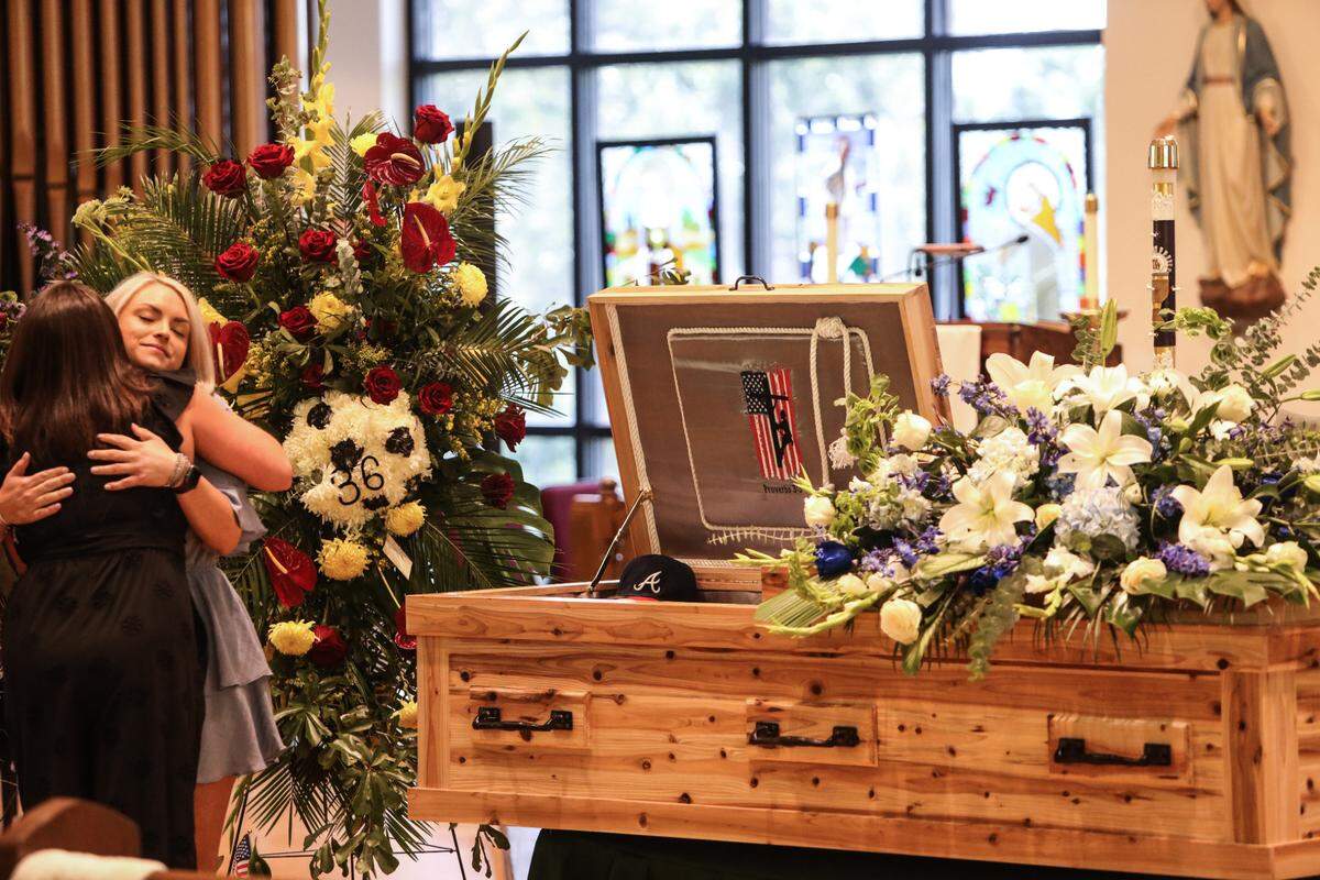 Cassie Lassabe, girlfriend of Cayce Seal, hugs a guest during his funeral service at St. Clare Catholic Church in Waveland on July 1, 2021.