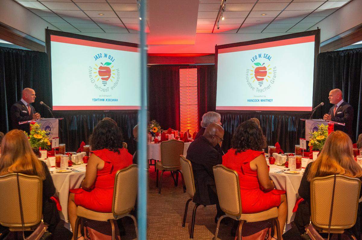 Paul Maxwell, Vice President and Senior Communications Officer for Hancock Whitney, is reflected in a mirror as he presents the Leo W. Seal teachers awards and grants at the Great Southern Club in Gulfport on Friday, Aug. 26, 2022.
