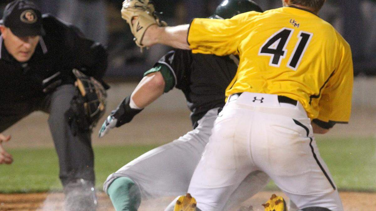 JOHN FITZHUGH/SUN HERALD 
 Tulane's Jarret Dehart scores on a wild pitch by USM's Houston Case (41) during a game at MGM Park in Biloxi on Tuesday March 22, 2016. The NCAA is 'monitoring' the HB 1523 situation.