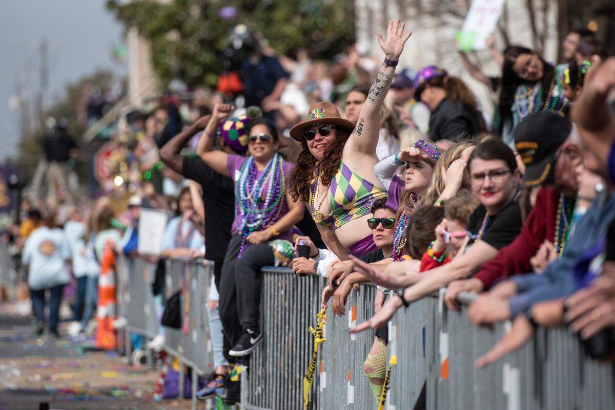 Parade watchers catch beads and other throws during the Gulf Coast Carnival Association Mardi Gras parade in Biloxi on Tuesday, March 4, 2025.